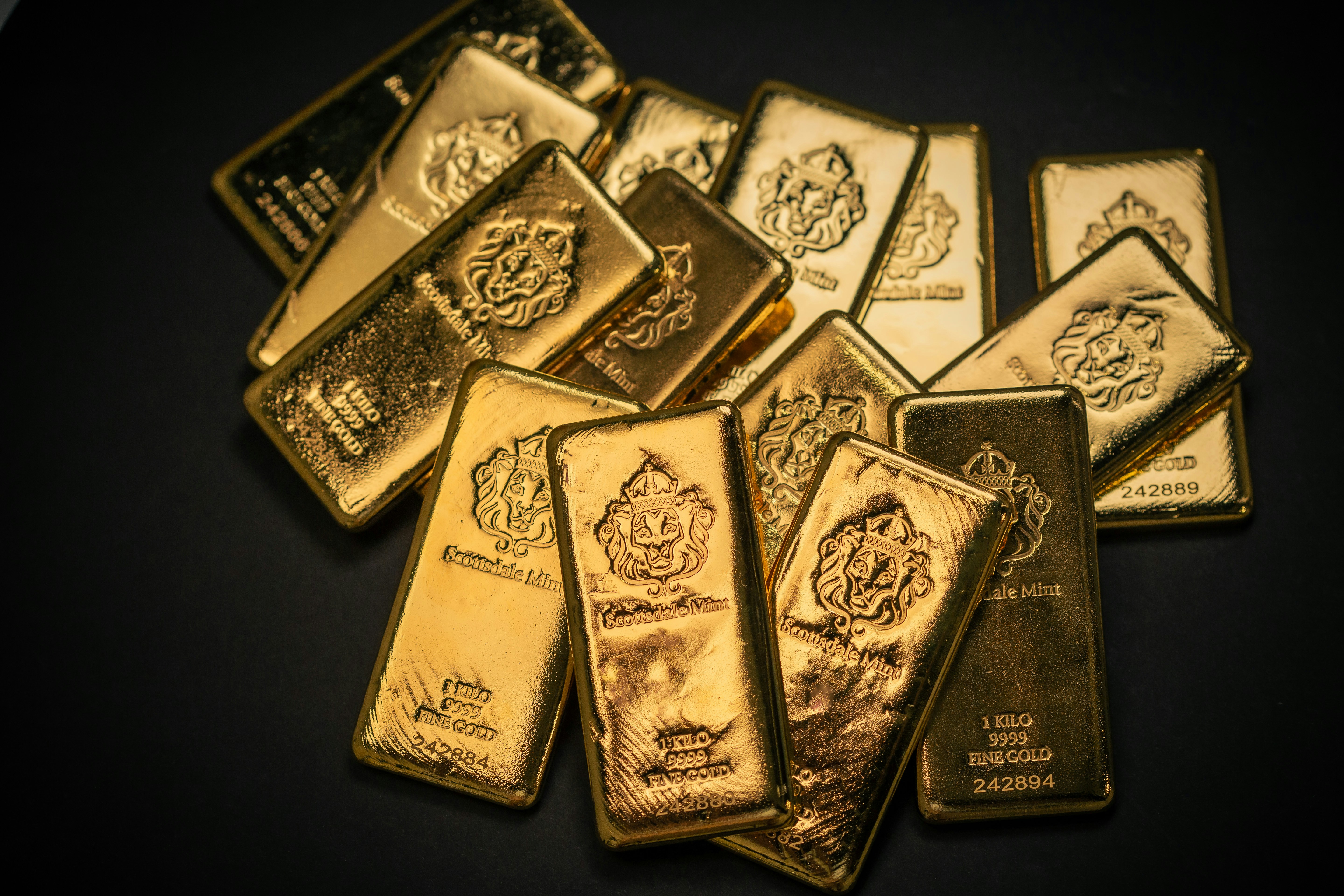 Scottsdale Mint 1 Kilo Gold Bullion Bars sitting on a simple textured backdrop. Each bar is pure 9999 Fine and made from gold precious metals. Please give a shoutout to Scottsdale Mint if able! Shop online for the most beautiful bullion at ScottsdaleMint.com!